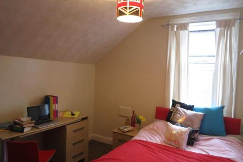 A bright and cozy bedroom featuring a large win...