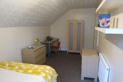 A cozy student accommodation room featuring a b...