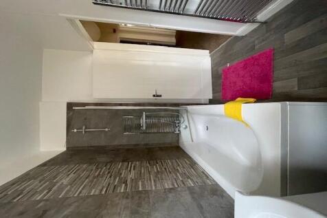 A modern bathroom featuring a spacious bathtub,...
