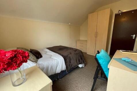 Cozy single bedroom featuring a neatly made bed...