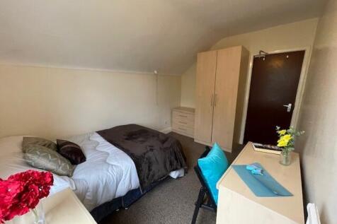 A cozy single bedroom featuring a comfortable b...