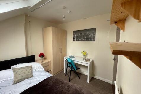A cozy and tidy bedroom featuring a comfortable...