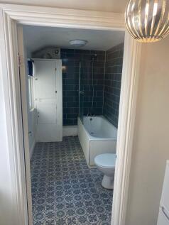 A functional bathroom featuring a bathtub, toil...