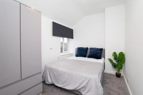 A clean and well-lit double bedroom featuring a...