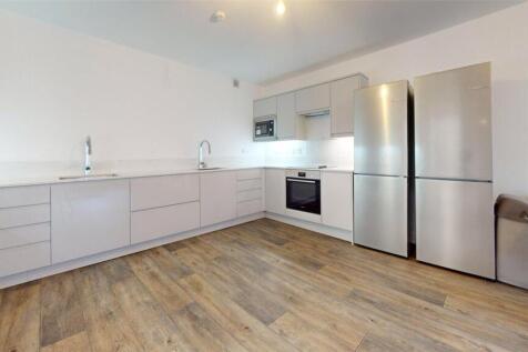 Modern, minimalist kitchen with clean white cab...