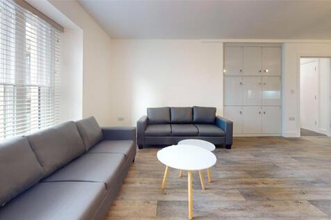 Bright and airy living room featuring large win...