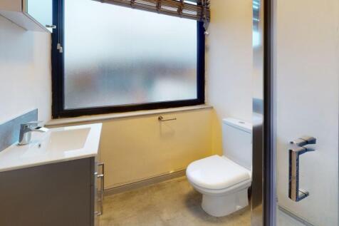 Bright and functional bathroom with a frosted w...