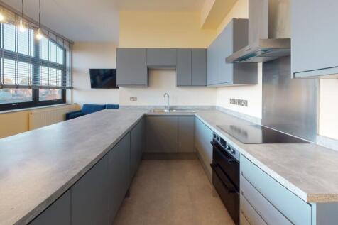 A modern, well-lit kitchen featuring sleek grey...