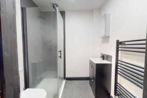 A clean and modern bathroom featuring a walk-in...