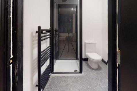 A modern bathroom featuring a glass-enclosed sh...