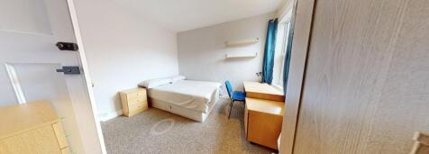 A cozy bedroom featuring a comfortable bed, a d...