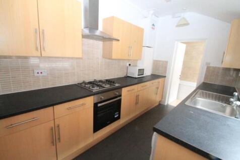 A modern kitchen featuring light wooden cabinet...