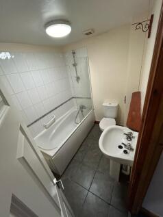 A functional bathroom featuring a bathtub with ...