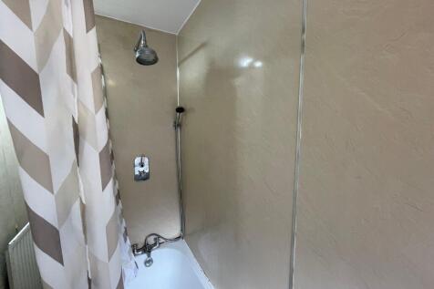 A spacious bathroom featuring a large bathtub, ...