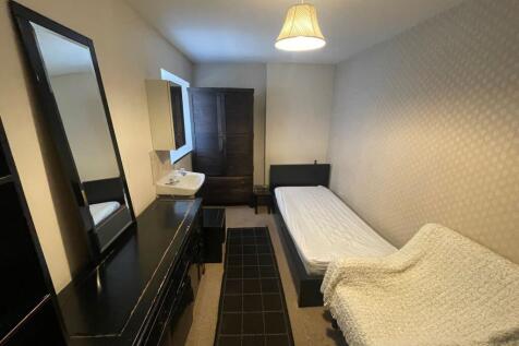 A cozy double bedroom featuring a single bed, a...