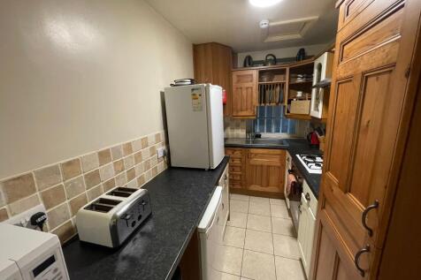 A well-maintained kitchen featuring warm wooden...