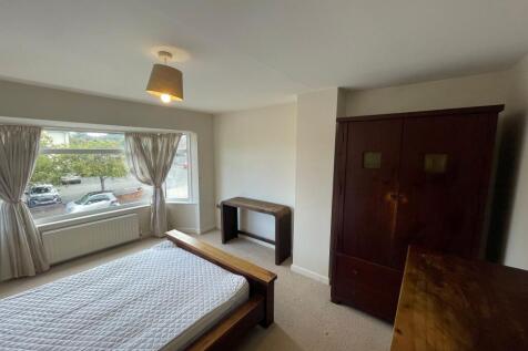 A bright and airy bedroom featuring a large win...