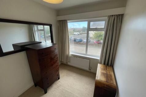 A bright and welcoming bedroom featuring a larg...