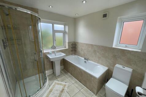 A bright, modern bathroom featuring a spacious ...