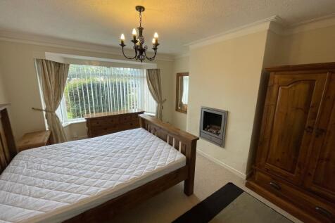 A well-maintained bedroom featuring a large win...