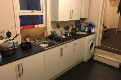 A functional kitchen with a black countertop, w...