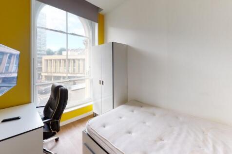 A bright and tidy bedroom featuring a comfortab...