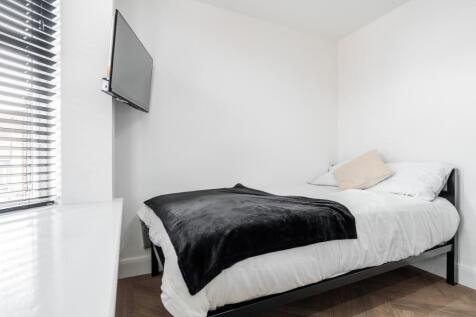A tidy and bright single bedroom featuring a co...