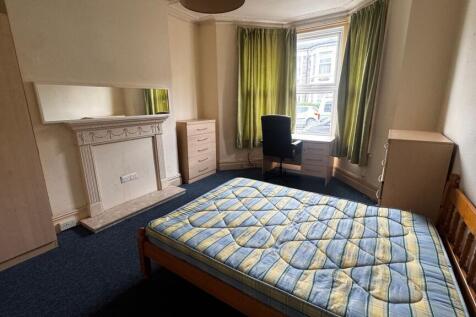A cozy bedroom featuring a wooden bed frame wit...