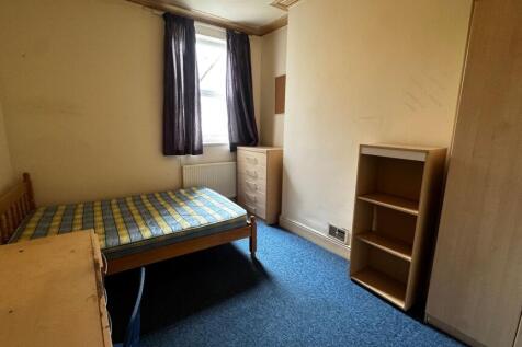 A modest single bedroom featuring a single bed,...