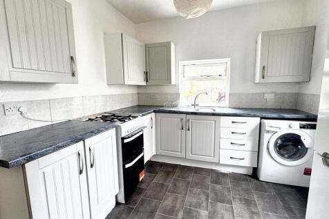 Bright and modern kitchen with ample storage, a...
