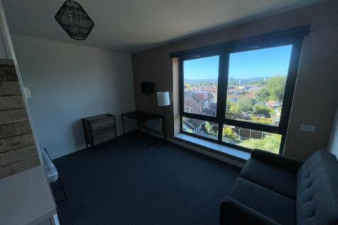 Bright and spacious living room with large wind...