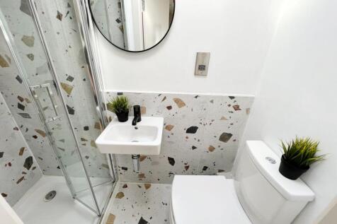 A modern bathroom with a white toilet and a sma...