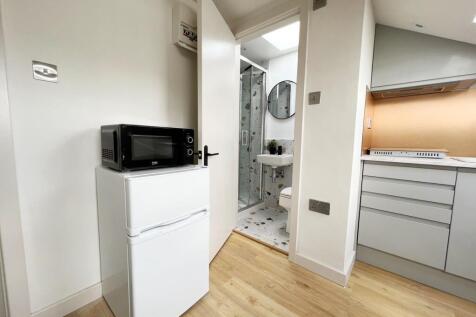Modern kitchen with compact appliances and ligh...