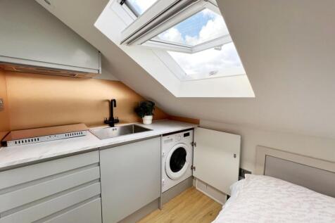 Bright and modern kitchen area with a large sky...