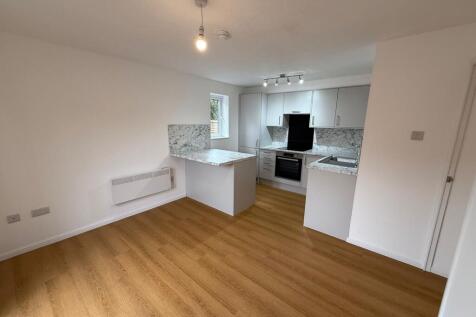 Modern kitchen featuring sleek white cabinets, ...