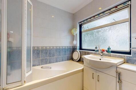 A spacious bathroom featuring a large bathtub, ...