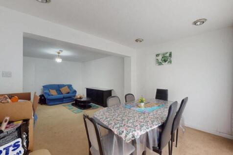 A spacious and well-lit living room featuring a...