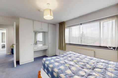 Spacious master bedroom featuring a large bed, ...