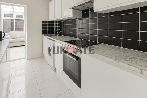 Modern, bright kitchen featuring sleek white ca...