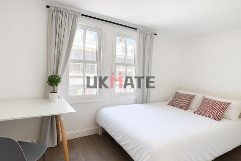 Bright and airy master bedroom with large windo...