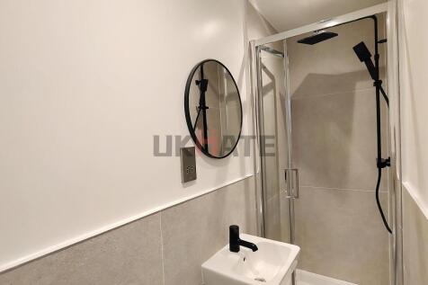 A clean, modern bathroom featuring a walk-in sh...