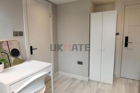 A bright and tidy bedroom featuring a white war...