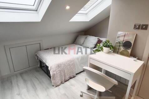 A bright, cozy bedroom with two skylight window...