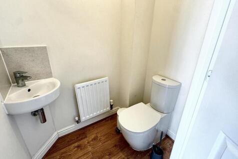 A compact and clean single toilet room featurin...