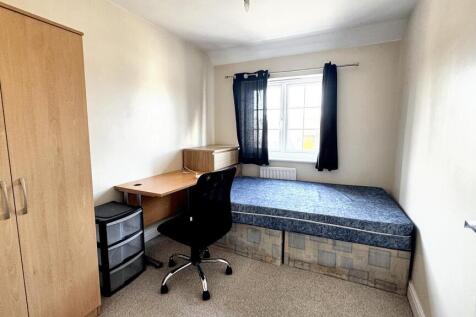 Cozy single bedroom featuring a built-in desk w...