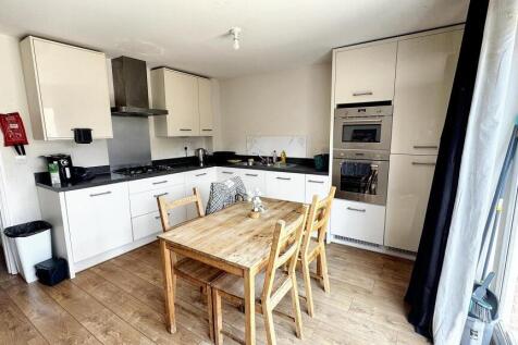 Bright and modern kitchen with white cabinetry ...