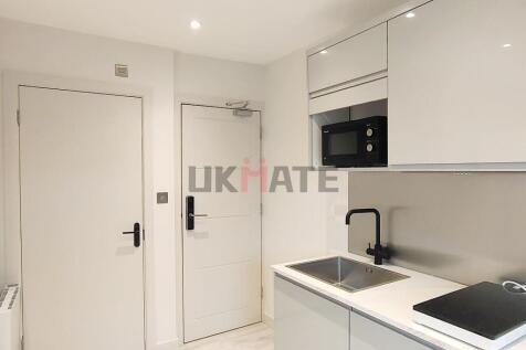 Modern and minimalist kitchen with white cabine...