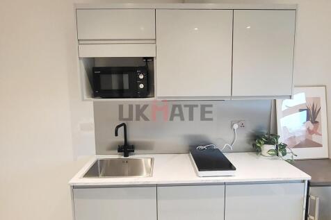 Modern, minimalist kitchen featuring sleek whit...