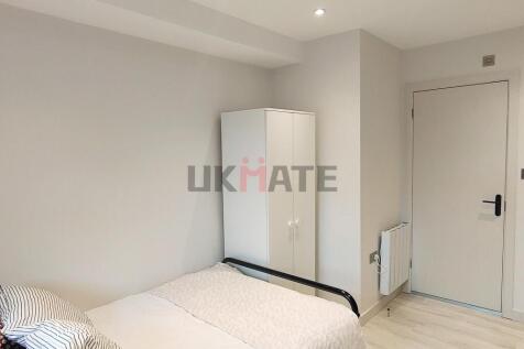 A bright and tidy bedroom featuring a comfortab...