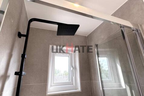 A modern bathroom featuring a sleek walk-in sho...
